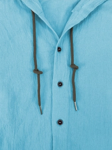 Close-up of light blue cotton linen hoodie with dark brown drawstrings and buttons