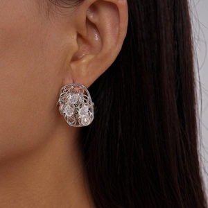 Gros plan de boucles d'oreilles argentées avec perles facettées transparentes sur modèle