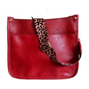 Red faux leather tote bag with leopard print shoulder strap and gold metal hardware