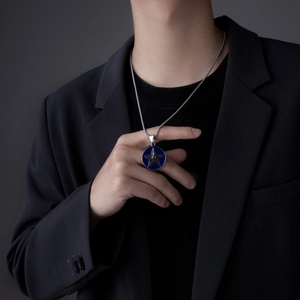 Collier rond bleu pour homme avec étoile argentée porté sur une tenue de ville noire