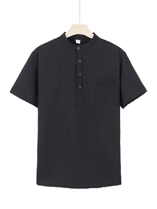 Detail of black waffle knit polo shirt showing textured fabric, buttons, and chest pocket
