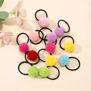 Detailed view of colorful plush pom pom hair ties in various vibrant candy colors