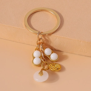 Detail of golden peanut pendant with white jade-like bead and lucky blessing coin