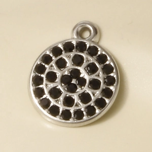 Macro view of silver stainless steel round pendant with black pave-set rhinestones