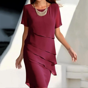 Detail van de wijnrode chiffon stof en ronde hals op een nauwsluitende midi-jurk