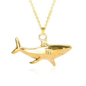 Macro shot of polished gold shark pendant with detailed gills and smooth metal finish