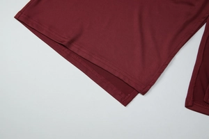 Detailansicht des dunkelroten Kleiderstoffs mit hochwertigen Nähten und Textur