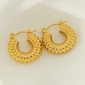 Detailed macro view of gold-plated stainless steel hoop earrings with a spiral twisted pattern