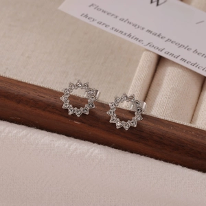 Boucles d'oreilles créoles argentées avec cristaux sur support en bois et tissu beige