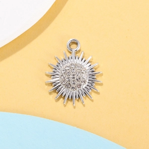 Macro detail of silver snowflake sun pendant with clear crystals and metal ring