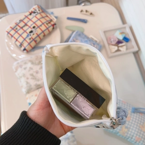 Detail view of mini cotton pouch interior showing capacity for lipstick and cosmetics
