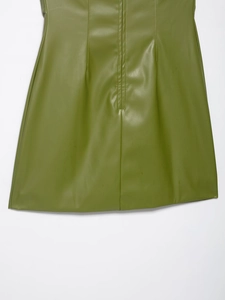 Détail de la robe en similicuir olive montrant les coutures et la texture lisse