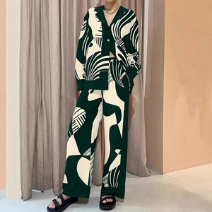 Détail du motif vintage vert foncé sur le pantalon taille haute et la chemise assortie