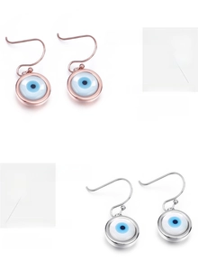 Détail de boucles d'oreilles œil protecteur en or rose et argent avec émail bleu