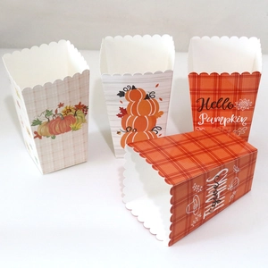 Detailed view of four Thanksgiving paper popcorn boxes with pumpkin and plaid patterns