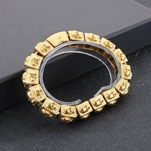 Close-up of golden stainless steel skull links with embossed vintage textures