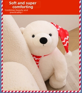 Close-up of plush Christmas polar bear wearing a festive red hat and striped scarf