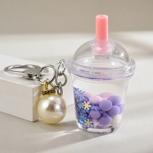 Close-up of a bubble tea keychain with purple liquid and pearls on a metal keyring