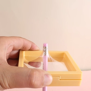 Yellow square PE film suspension jewelry box showing high elasticity with a pencil
