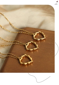 Détail de trois pendentifs cœur dorés avec texture bambou sur une chaîne de type torsadé