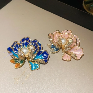 Macro detail of French flower brooches with enamel petals, pearls and sparkling crystals