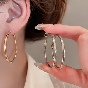 Chic minimalist large metal hoop earrings in polished gold and silver finish for women