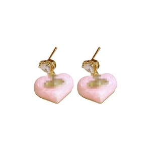 Golden heart earrings with pink marble enamel and sparkling rhinestones on white backdrop