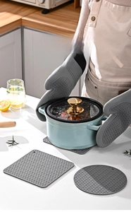 Detailed view of thick grey silicone oven gloves and mats with anti-slip wave texture