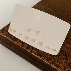 Detail view of 6 pairs of gold-plated geometric stud earrings with zircon on a card
