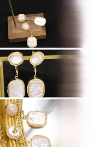 Detailed macro view of baroque natural pearl earrings with gold wire-wrapped craftsmanship