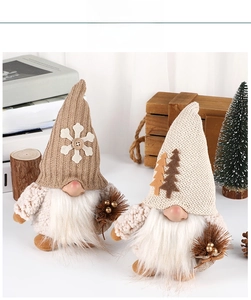 Close-up of handmade Christmas gnomes with knitted hats and snowflake details on a wooden base
