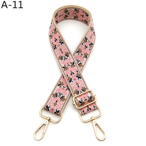 Close-up of adjustable pink floral guitar style strap with polished gold hardware