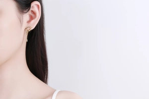 Detailed close-up of 18K gold-plated irregular streamlined earrings worn on a model