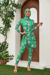 Detail of long-sleeved floral burkini featuring tropical palm leaf prints and pink accents