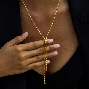 Elegant gold stainless steel Y-shaped necklace with small seed beads worn on a model