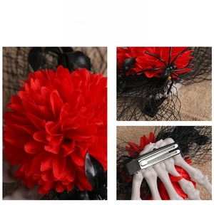 Detail view of Halloween skeleton hand hair clip with red rose, mesh, and spider