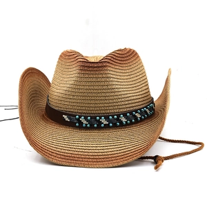 Close-up of woven straw cowboy hat with ethnic bead decorative band and chin strap