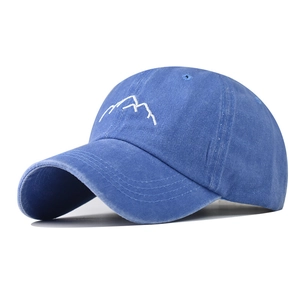 Detailed embroidery of white mountain peaks on a navy blue washed cotton baseball cap