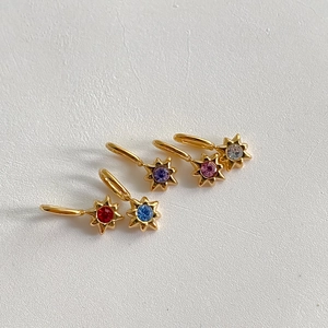 Macro-detail van 14K vergulde sterhangers met kleurrijke zirkonia steentjes bezet