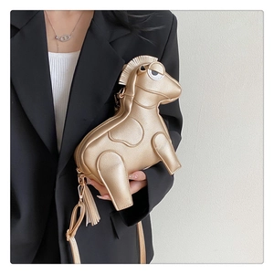 Detail showing a golden horse-shaped crossbody bag with tassels on a black blazer