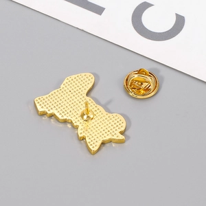 Macro shot of gold-plated cat enamel pin back showing metal texture and butterfly clasp