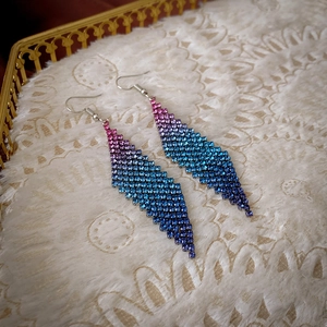 Vue détaillée des boucles d'oreilles à pompons géométriques avec cristaux bleu dégradé