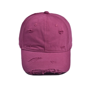 Close-up of distressed vintage deep purple baseball cap with ripped hole details
