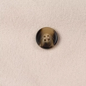 Macro shot of brown tortoiseshell four-hole buttons on beige textured wool fabric