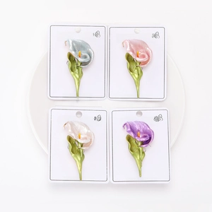 Detail of four colorful calla lily brooches with glossy enamel finish on display cards