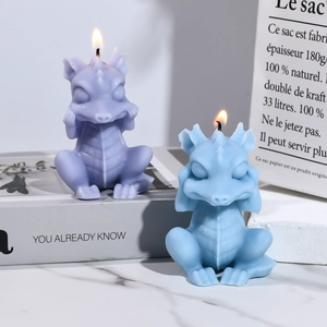 Detalle de velas aromáticas con forma de pequeño dragón en lavanda y azul sobre decorado
