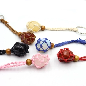 Close-up of six handmade braided net keychains with assorted natural crystal gemstones