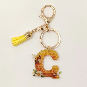 Detail of Letter C acrylic bee keychain with yellow tassel and gold lobster clasp