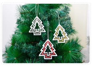 Close-up of glittery hollow Christmas tree wooden ornaments hanging on green branches