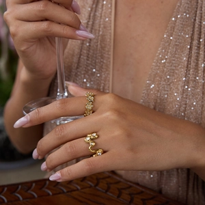 Détail de bagues dorées fleurs et vagues avec pavé de zircons pour la soirée